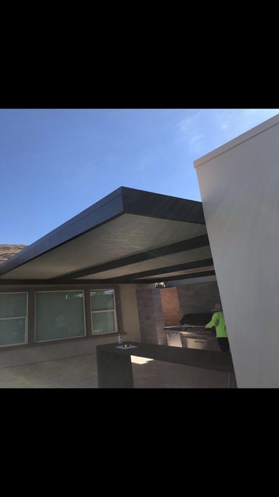 Overhead view of a patio with a grill and clear sky.